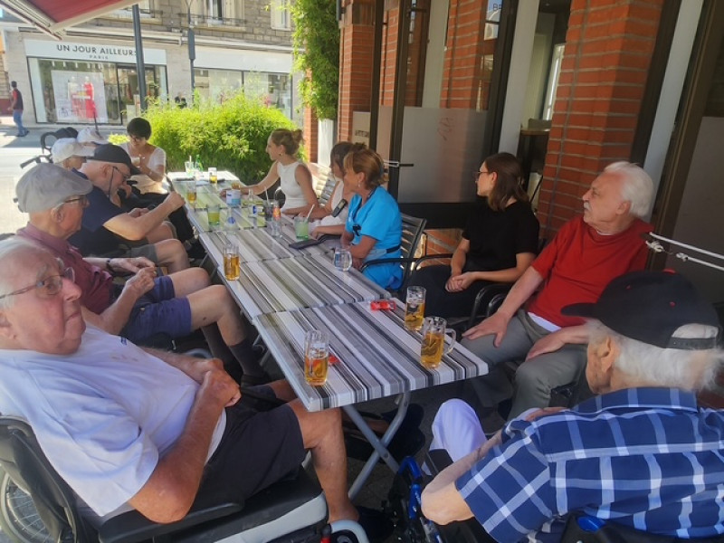 Sortie conviviale en ville : une bière en terrasse pour les hommes de la résidence La Harpe